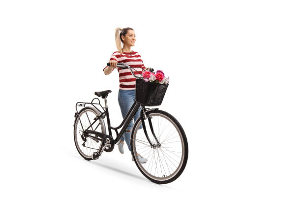 Young woman pushing a bicycle Full length portrait of a young woman pushing a bicycle isolated on white background bicycle basket stock pictures, royalty-free photos & images