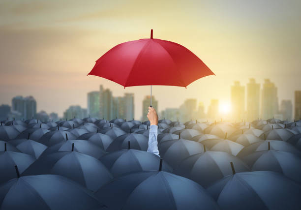 istock businessman with red umbrella among others, unique different concept 980134354