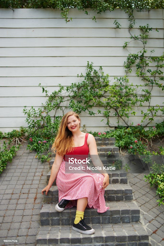 I'm nicer when I like my outfit Shot of a beautiful young woman sitting on steps outside 20-29 Years Stock Photo