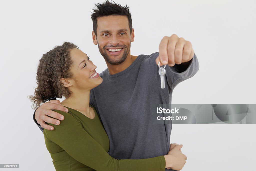 Junges Paar hält einen Schlüssel, isoliert auf weiss - Lizenzfrei Paar - Partnerschaft Stock-Foto