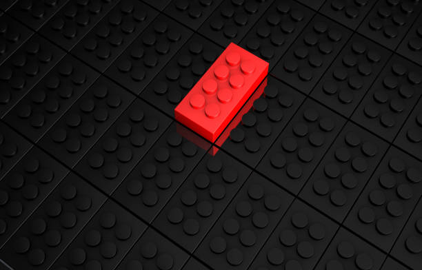 istock 3D rendering red toy bricks standing out from crowd of black toy bricks 980159918