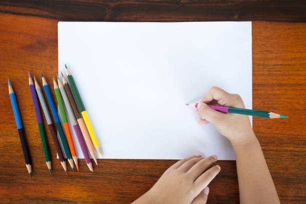 istock Asian little boy use color pencil writing 980176072