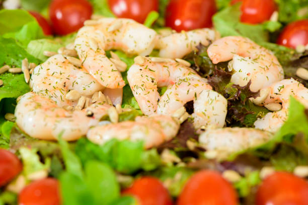 sea salad topped in transparent tub with shrimp