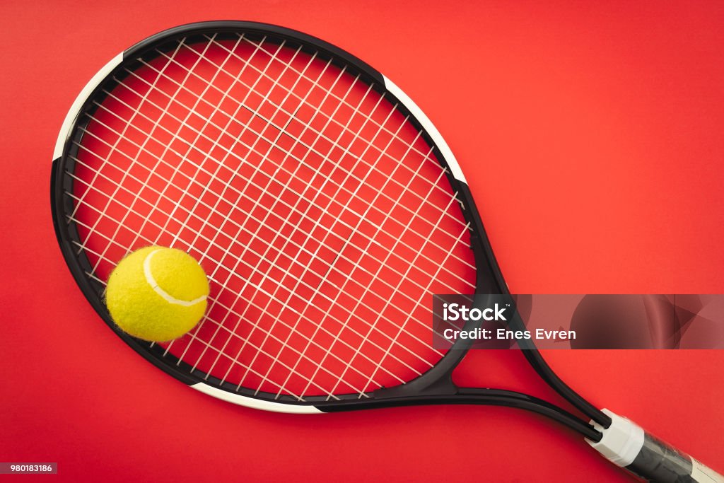 Tennis racket and tennis ball on the red clay court Tennis Racket Stock Photo