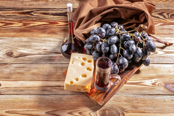 istock Red wine, cheese and red grapes on a wooden background. Top view 980186206