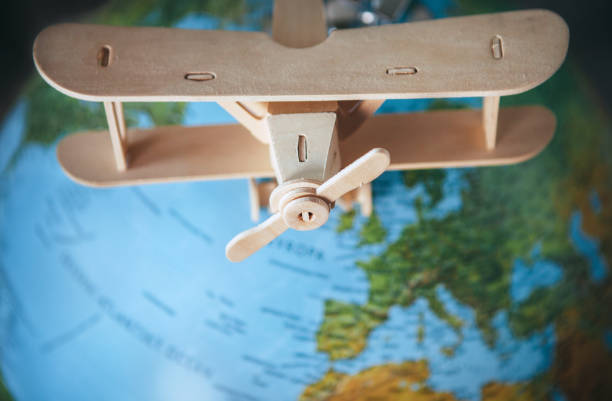 istock Wooden model vintage airplane is on the Earth globe 980186430