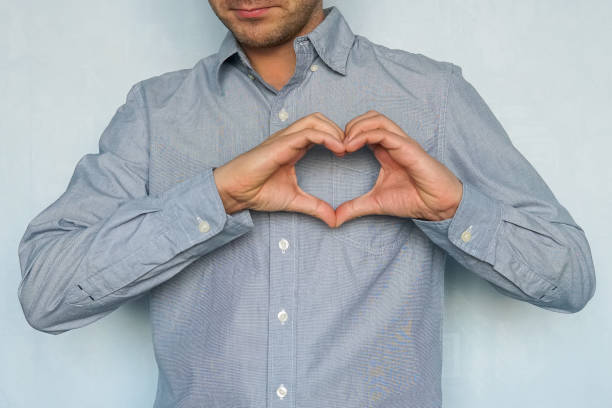 istock happy handsome man making heart with fingers. 980190768