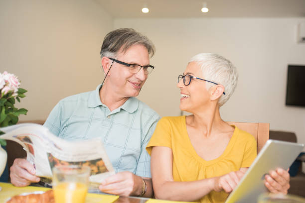 istock Married couple with digital tablet and newspapers 980203030