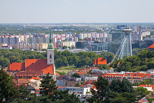 Bratislava, Slovakia - June 18 2018: Cityscape of Bratislava with the St Martin's Cathedral, the St. Nicholas' Church and the UFO Observation Deck of the Novy Most bridge.