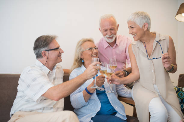 istock Two happy couples having wine celebratory toast 980219822