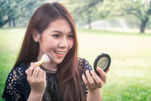 istock Beautiful young woman make up in the park 980220154