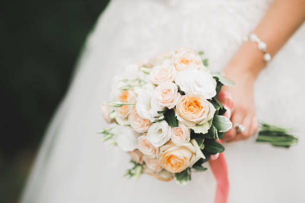 istock Bride holding big and beautiful wedding bouquet with flowers 980224502