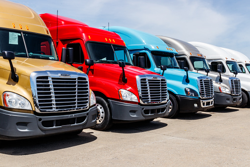 Indianapolis - Circa June 2018: Colorful Freightliner Semi Tractor Trailer Trucks Lined up for Sale. Freighliner is owned by Dailmer Trucks IV