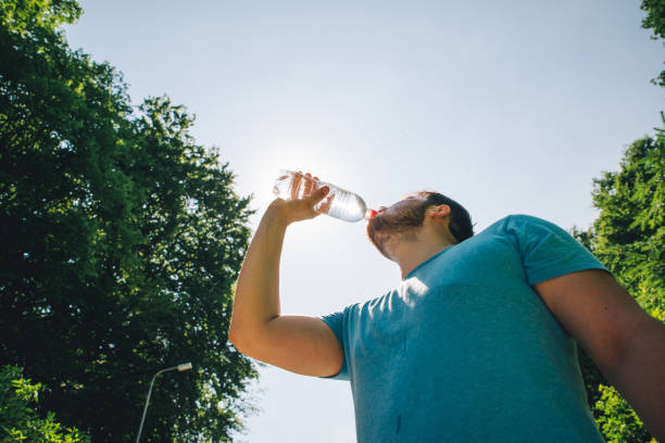 istock man drinking water in hot summer day. copy space 980229896