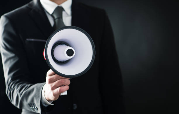 istock Business man holding a megaphone in dark background 980230026