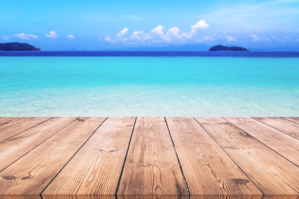 istock Wood table with blue sea and sand beach background 980233356