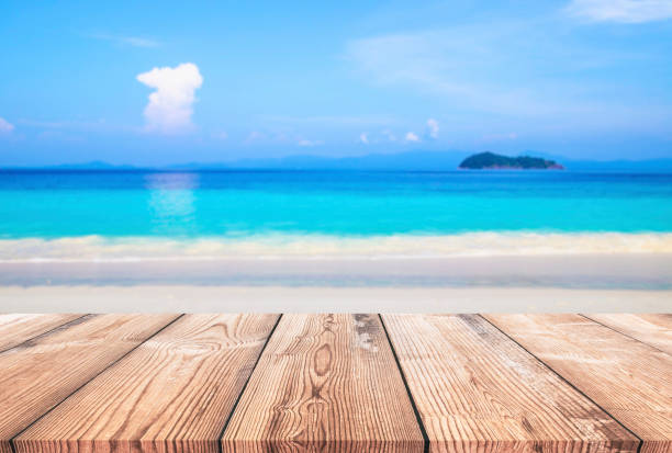 istock Wood table with blue sea and sand beach background 980233406
