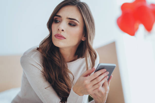istock Cheerless sad woman holding her smartphone 980240516