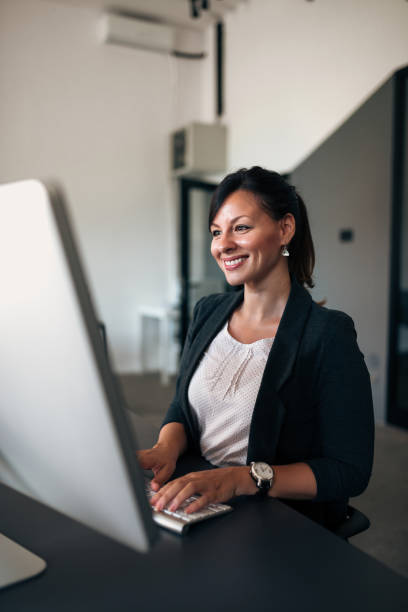 istock Smiling elegant woman typing on computer keyboard. 980241354