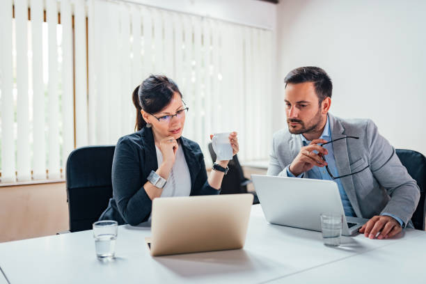 dos hombres de negocios discutiendo delante del ordenador portátil de datos en línea. - 5954 fotografías e imágenes de stock