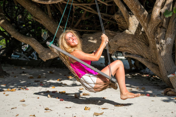 istock Gorgeous blond woman is rocking under the tree 980244444