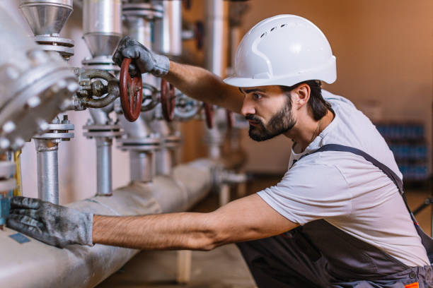 istock Worker with helmet in front of pipes with valves 980247672