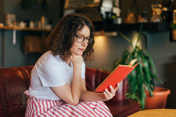 istock Young woman reading at home 980252240