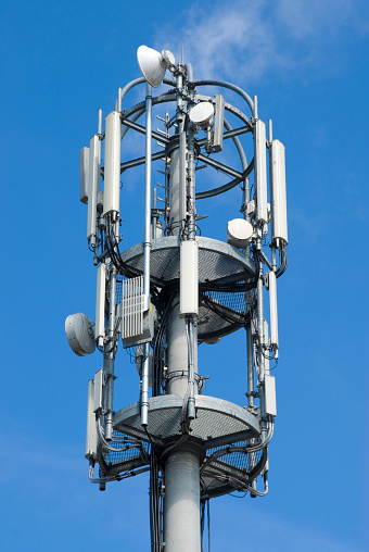 Signal or mobile phone tower against blue sky. Radio antenna. Modern telecommunication by using 5g or 4g internet.