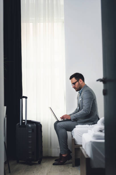 istock Businessman using laptop computer, working at his hotel room 980259762
