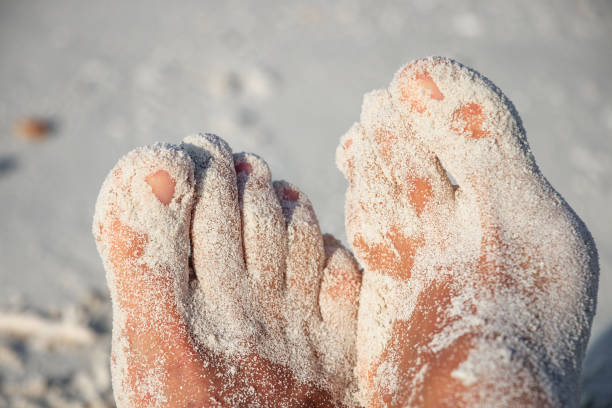 Sandy mens feet on the sandy beach