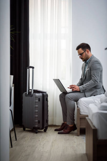 istock Businessman using laptop computer, working at his hotel room 980260228