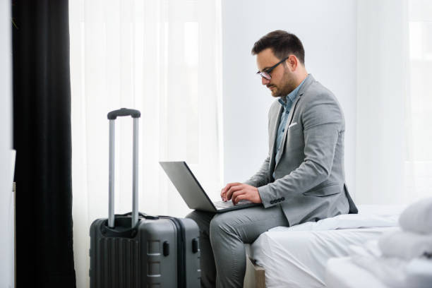 istock Businessman using laptop computer, working at his hotel room 980260232
