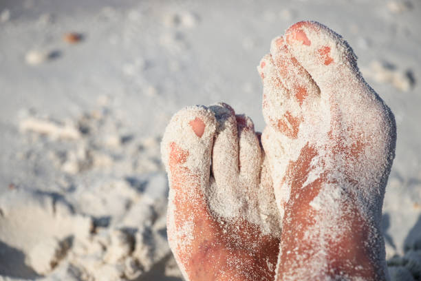 istock Sandy mens feet on the sandy beach 980260248