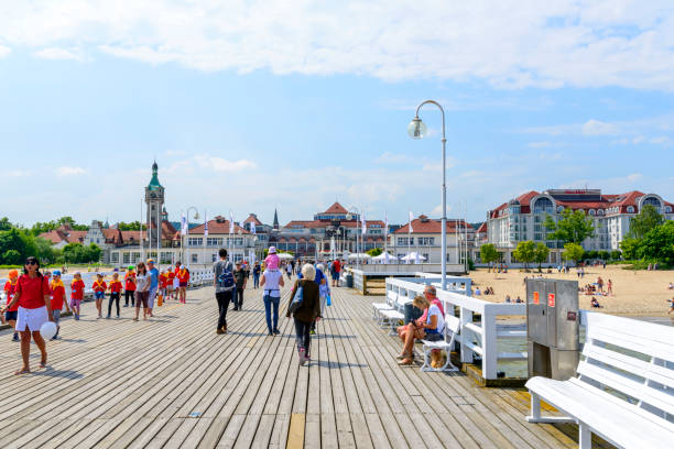 Tourists enjoy the sunny weather and walking along the pier in Sopot, Poland.