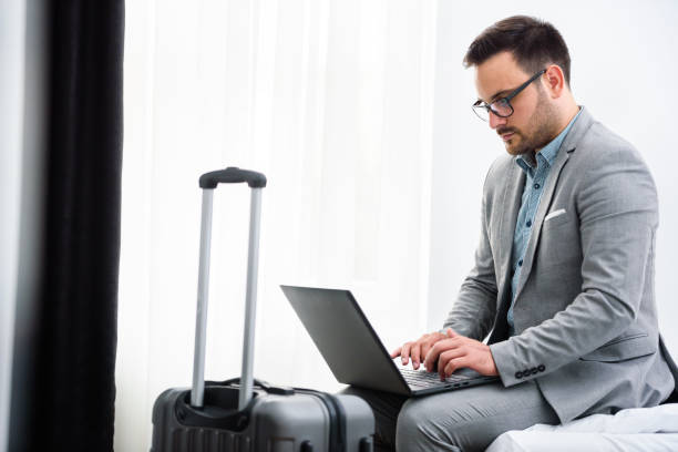 istock Businessman using laptop computer, working at his hotel room 980260424