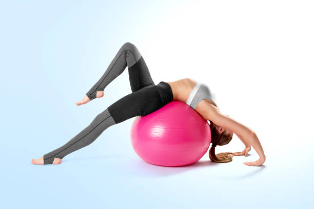 pilates et fille de sport de remise en forme qui s’étend sur le ballon de fitness yoga rose. entraînement avec la la balle rose de pilates. mode de vie sain - 4811 photos et images de collection