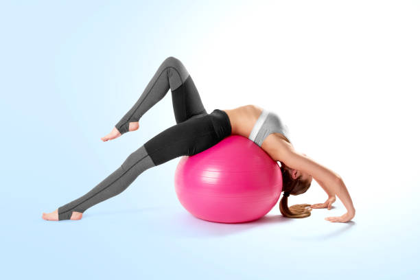 pilates and fitness sport girl stretching over the pink yoga fitness ball. indoor training with the the pink pilates ball. healthy lifestyle - 4811 imagens e fotografias de stock