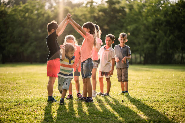 istock Kids playing together in public park 980303582
