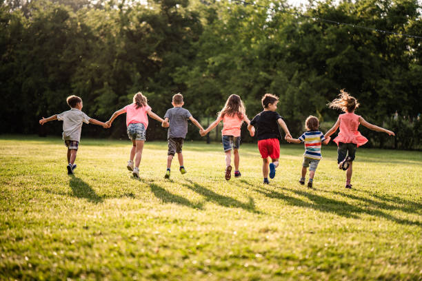 istock Back view group of children running in nature 980307296