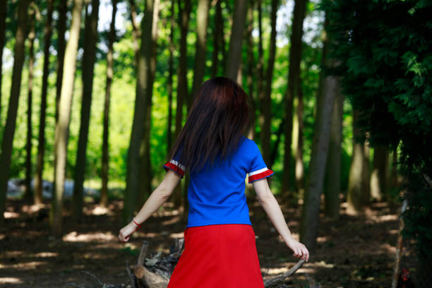 Woman standing with arms outstretched on forest