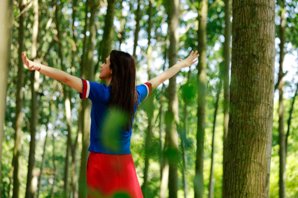 istock Woman standing with arms outstretched on forest 980313636