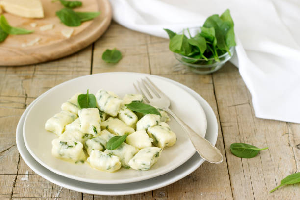 Homemade gnocchi with ricotta, cheese and spinach on a light plate. Homemade gnocchi with ricotta, cheese and spinach on a light plate. Selective focus. ricotta stock pictures, royalty-free photos & images