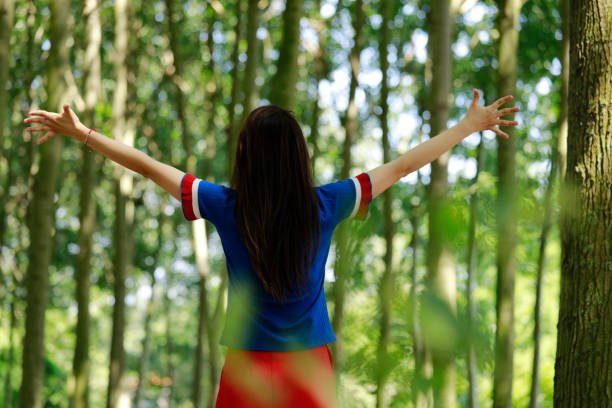 istock Woman standing with arms outstretched on forest 980313904