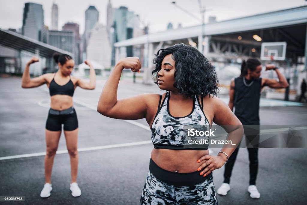 Female trainer with her trainees outdoors on rainy day Young people in United States using their free time to do some sports or physical activity. Exercising Stock Photo