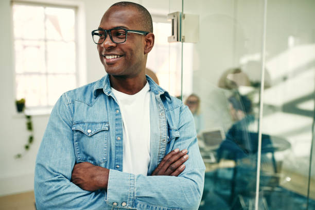 istock Smiling young African businessman standing in a modern office 980316906