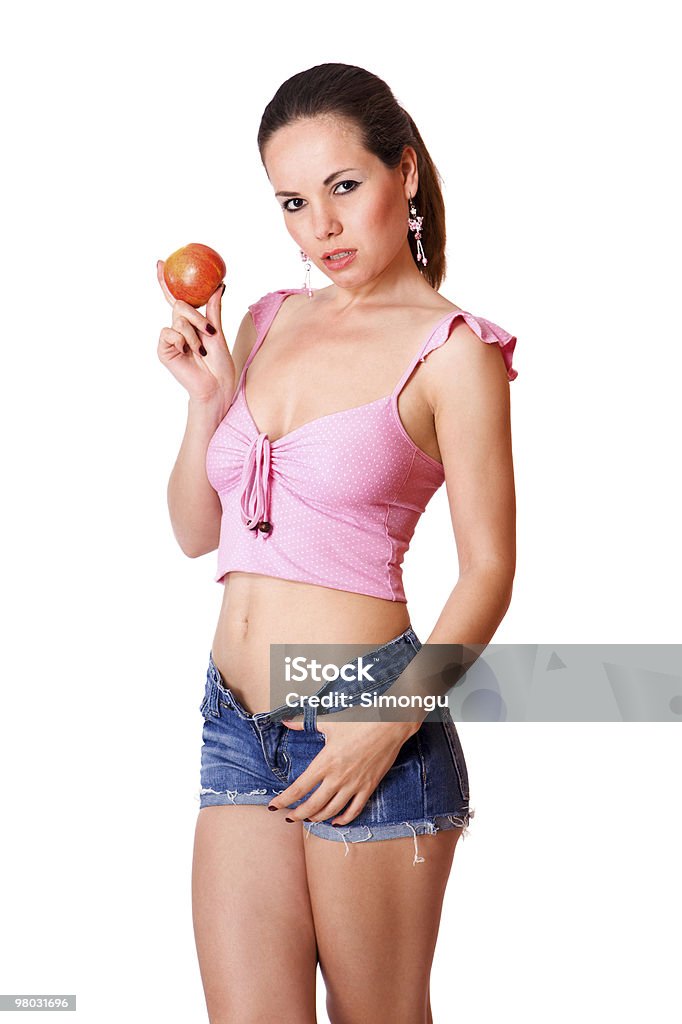 Niedliche Junge Mädchen in blue shorts hält einen Apfel, isoliert - Lizenzfrei Abgeschnittene Jeans Stock-Foto