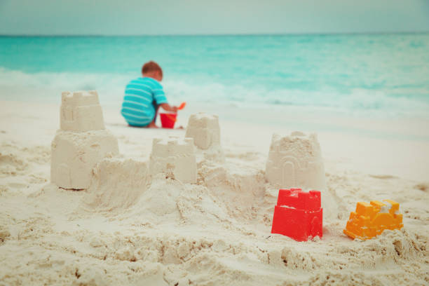 istock little boy building castle play with sand on beach 980317116