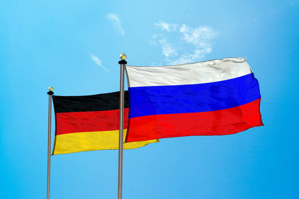 Russia vs Germany flag on the mast stock photo