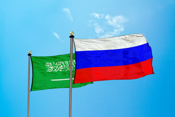 Russia vs Saudi Arabia flag on the mast stock photo