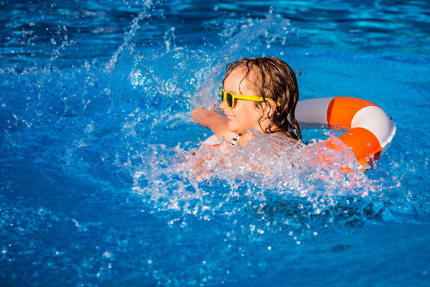istock Child playing in swimming pool 980342996